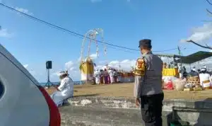 Bhabinkamtibmas Desa Kesiman Petilan Kawal Aman Upacara Melasti di Pantai Padang Galak