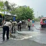 Sigap, Polisi bersama Damkar Bersihkan Tumpahan Solar di Jalan Raya Lamongan Antisipasi Kecelakaan