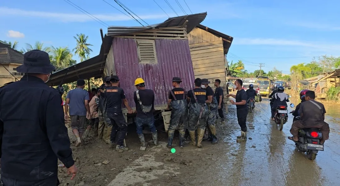 Bahu Membahu, Brimob Pindahkan Rumah Terseret Banjir yang Melintang di Jalan Nasional Tamiang–Langsa