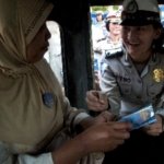 seorang anggota polwan menyematkan pin pada seorang penumpang angkot 130606213101 803