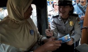 seorang anggota polwan menyematkan pin pada seorang penumpang angkot 130606213101 803